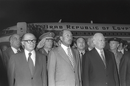 Le président égyptien Anwar Sadate à l'aéroport Ben Gourion le 19 novembre 1977, avec à sa gauche le président israélien Katzir et à sa droite le premier ministre Menahem Begin